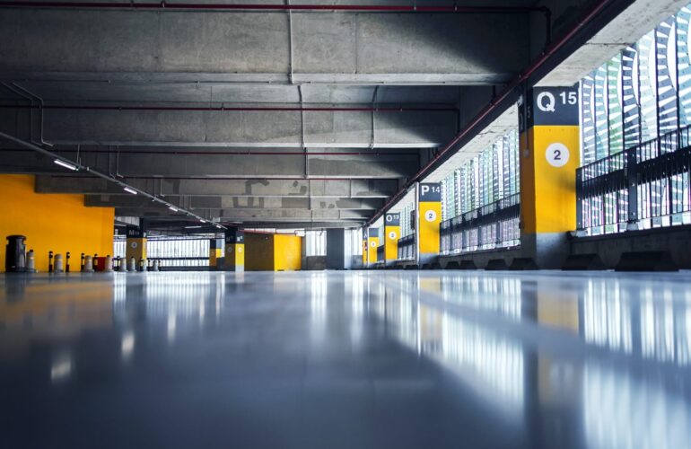Wnętrze parkingu wielopoziomowego z oświetleniem i słupami